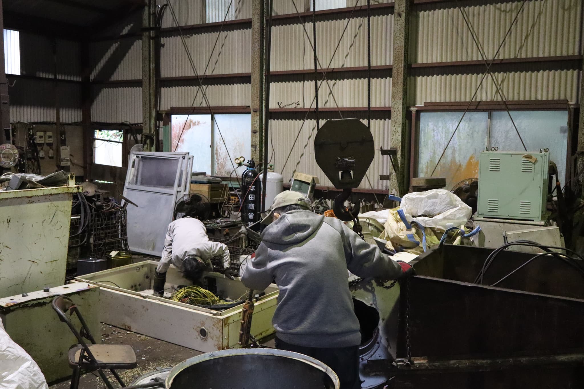 UCHIKAWAの屋内施設で廃機械・電気機器類を手作業で解体・分解する作業員の様子